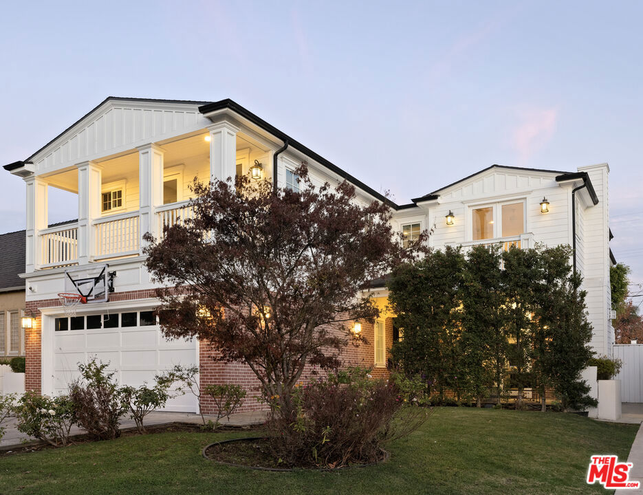 view of front of home with a lawn, a balcony, and a garage