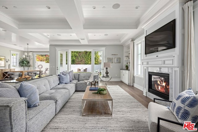 living room featuring a high end fireplace, coffered ceiling, crown molding, wood-type flooring, and beamed ceiling