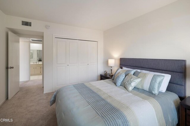 bedroom featuring light carpet, a closet, and sink