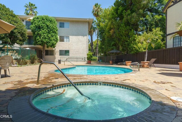 view of pool with a patio and a hot tub