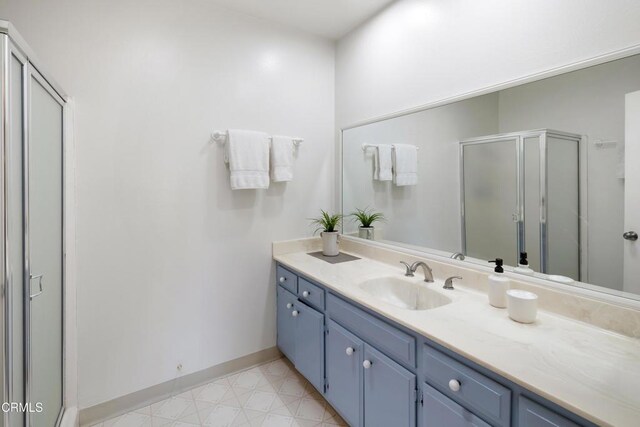 bathroom with a shower with door and vanity