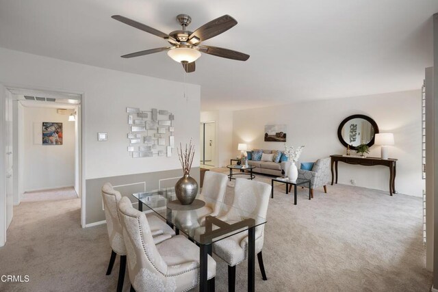 carpeted dining area featuring ceiling fan