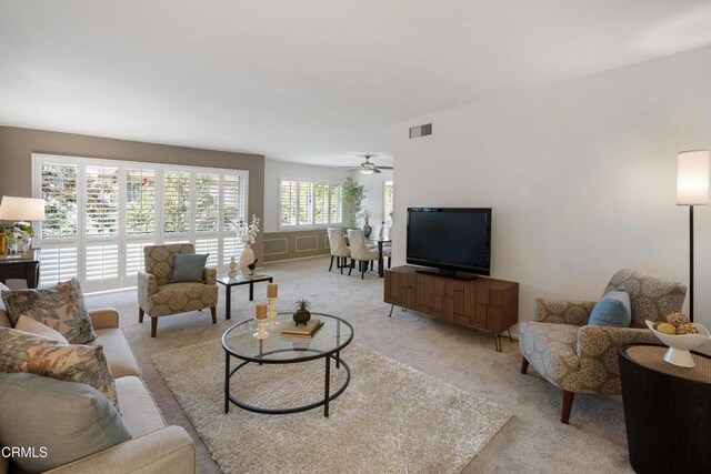 carpeted living room with ceiling fan