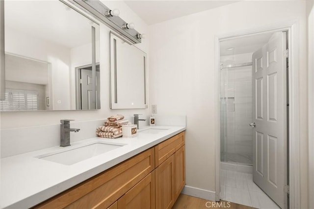 bathroom with hardwood / wood-style flooring, vanity, and an enclosed shower