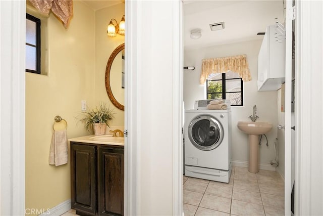 washroom featuring light tile patterned floors, washer / clothes dryer, and sink