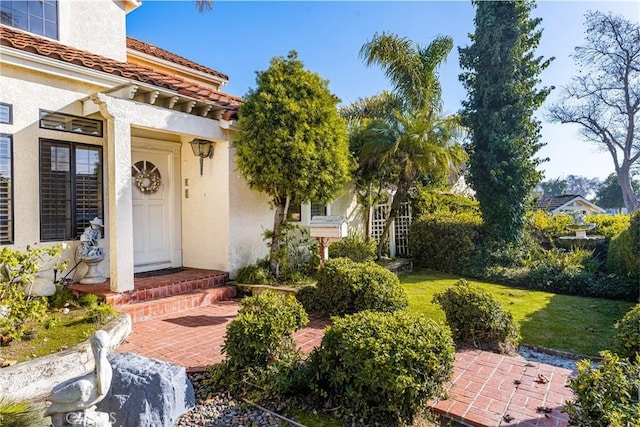 entrance to property featuring a lawn