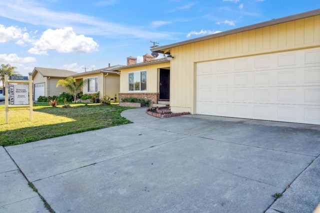 ranch-style house with a garage and a front lawn