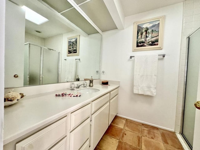 bathroom with vanity, walk in shower, and a skylight