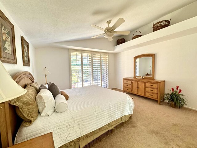 bedroom featuring light carpet, a textured ceiling, vaulted ceiling, and ceiling fan