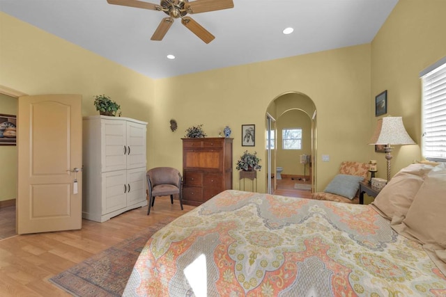 bedroom featuring ensuite bath, ceiling fan, and light wood-type flooring