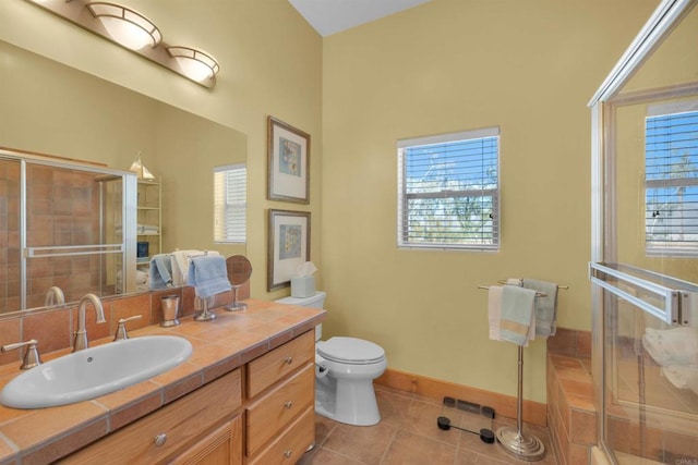 bathroom with tile patterned flooring, vanity, toilet, and an enclosed shower