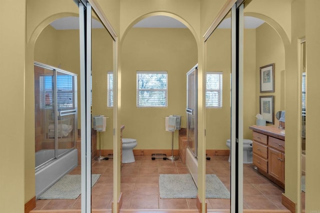 full bathroom with shower / bath combination with glass door, tile patterned floors, vanity, and toilet