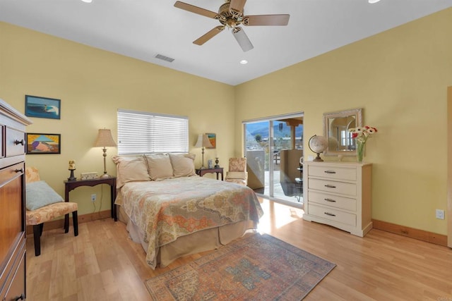 bedroom featuring access to outside, light hardwood / wood-style flooring, multiple windows, and ceiling fan