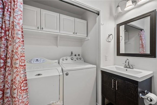 washroom with cabinets, independent washer and dryer, and sink