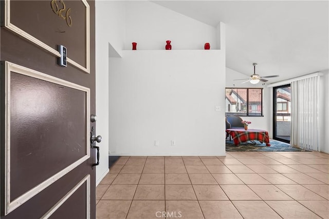 interior space featuring light tile patterned floors, high vaulted ceiling, and ceiling fan