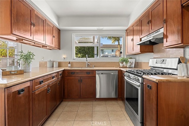 kitchen featuring light tile patterned flooring, stainless steel appliances, kitchen peninsula, and sink