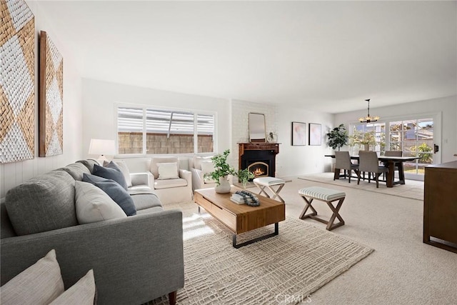 living room with carpet flooring, a fireplace, and a chandelier