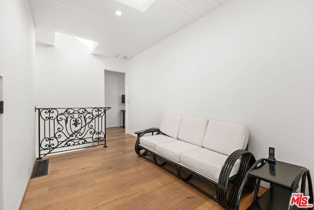 living room featuring light hardwood / wood-style floors and a skylight