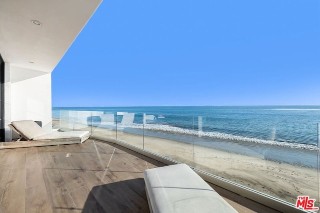 balcony with a beach view and a water view