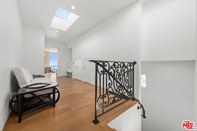 hall featuring light hardwood / wood-style floors and a skylight