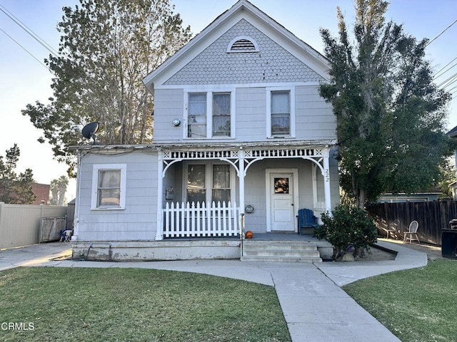 view of front of house featuring covered porch and a front lawn