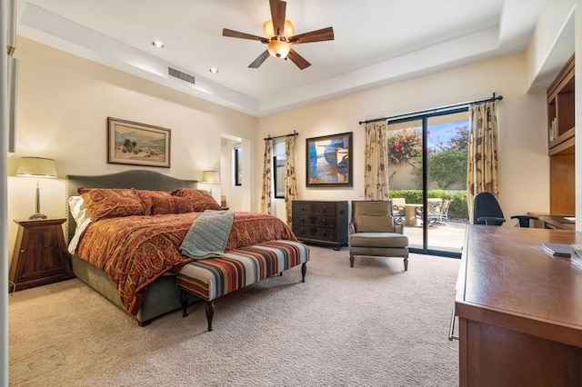 bedroom with access to exterior, light carpet, a raised ceiling, and ceiling fan