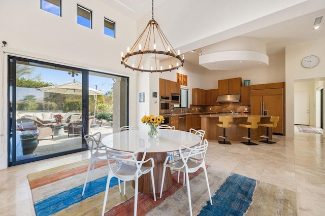 dining area featuring a chandelier, a high ceiling, and light tile patterned floors