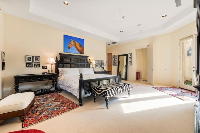 bedroom featuring a raised ceiling and light carpet