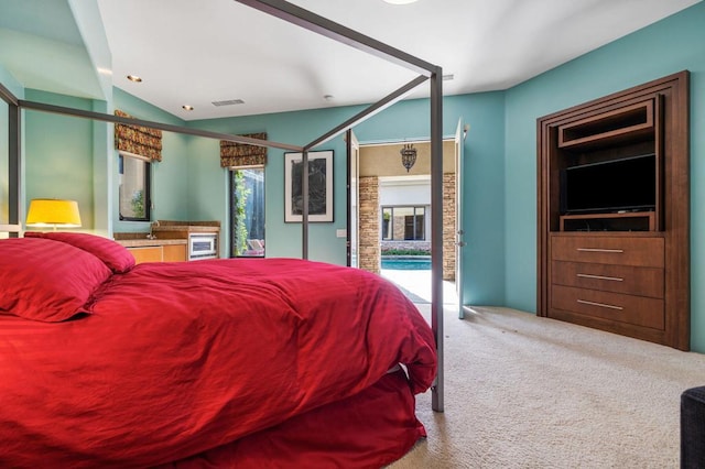 bedroom with lofted ceiling, access to exterior, and carpet floors