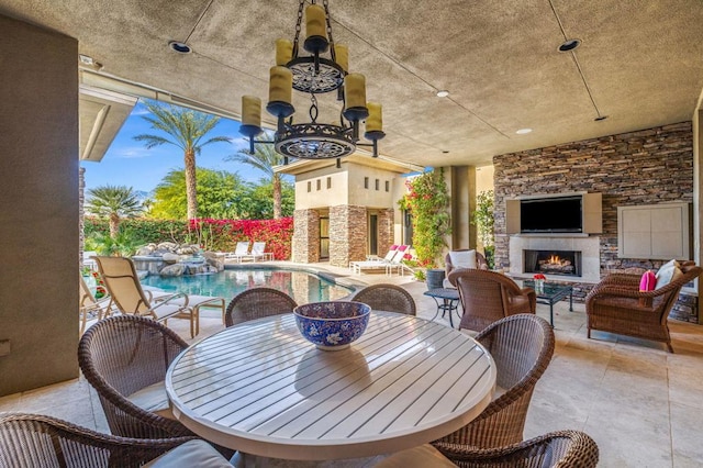 view of patio with an outdoor stone fireplace and a fenced in pool