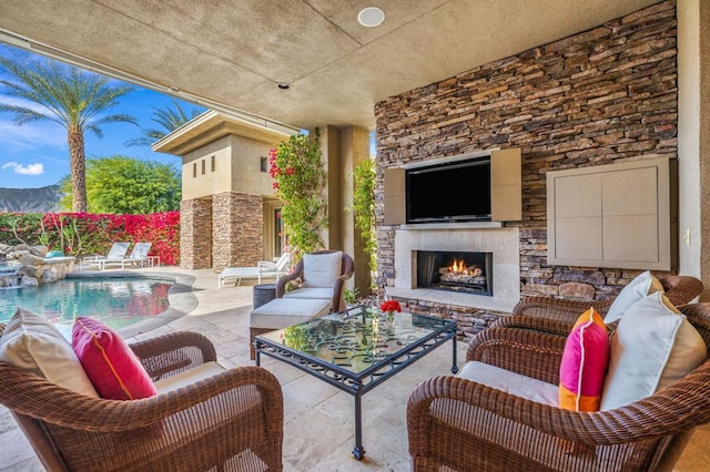 view of patio / terrace featuring a mountain view, an outdoor stone fireplace, and a fenced in pool