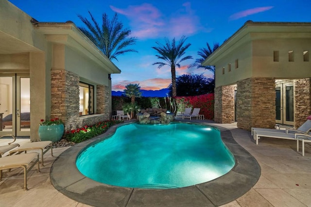 pool at dusk with a patio