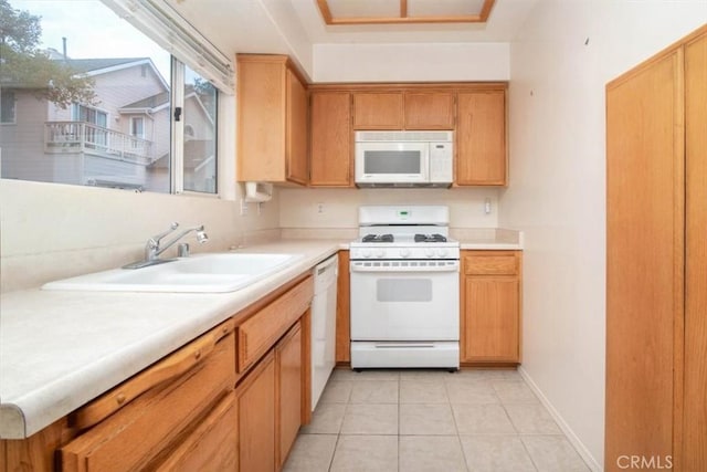 kitchen featuring white appliances, sink, and light tile patterned floors