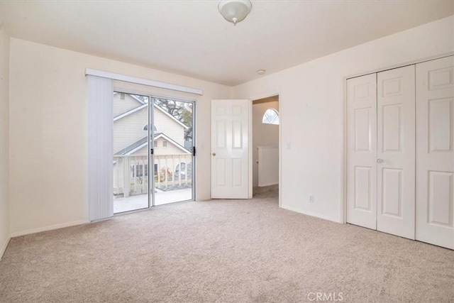 unfurnished bedroom with access to outside, a closet, and light colored carpet