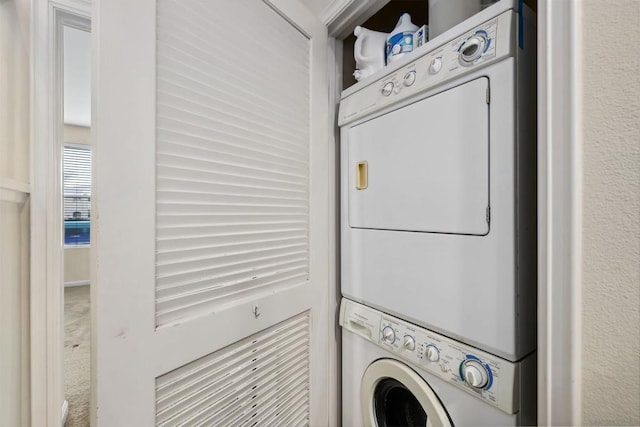 laundry area with carpet floors and stacked washer / dryer