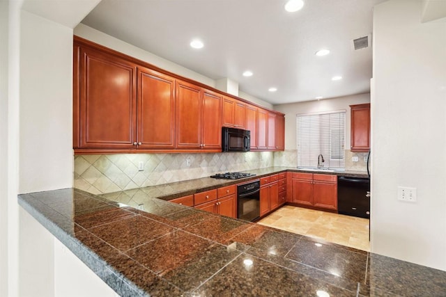 kitchen with kitchen peninsula, decorative backsplash, sink, and black appliances