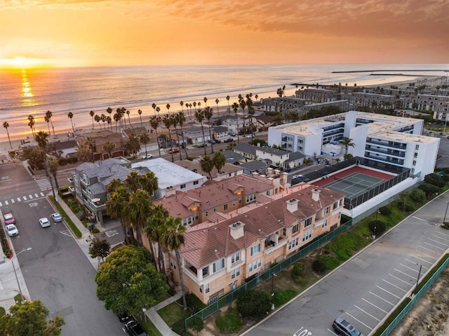 aerial view at dusk featuring a water view