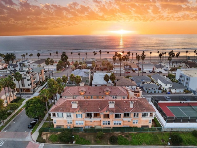 aerial view at dusk featuring a water view