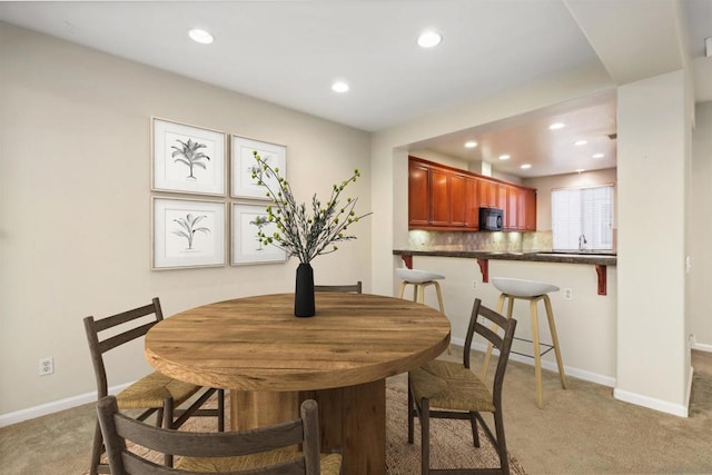 carpeted dining space featuring sink