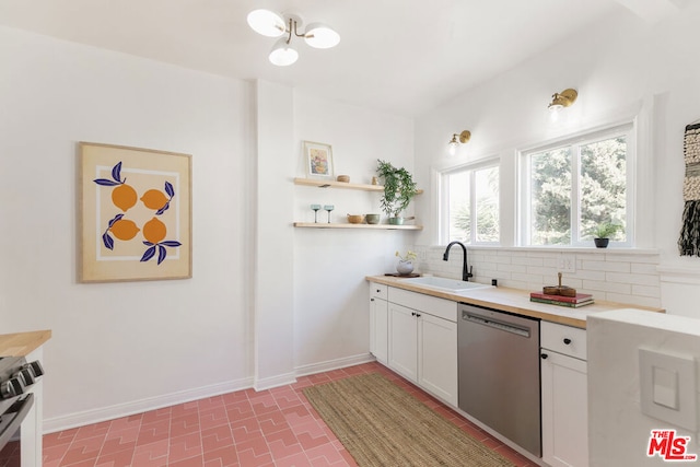 kitchen featuring stainless steel appliances, tasteful backsplash, sink, and white cabinets