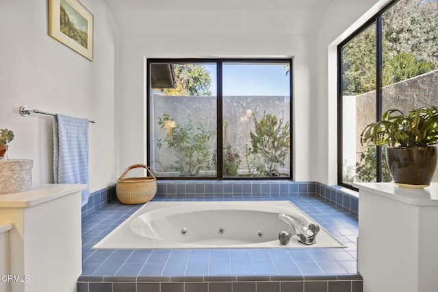 bathroom featuring plenty of natural light and a relaxing tiled tub