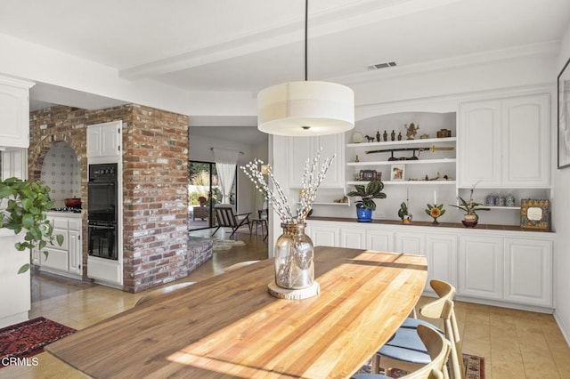 tiled dining room featuring beamed ceiling