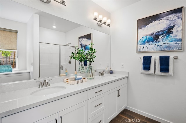 bathroom featuring hardwood / wood-style floors, vanity, and a shower with shower door