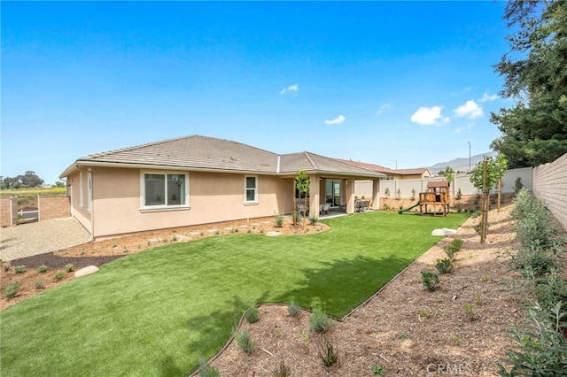 back of property featuring a yard, a playground, and a patio