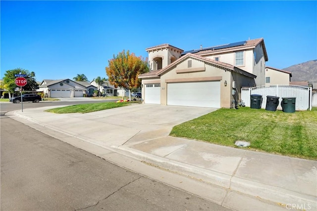 front of property featuring a front yard, solar panels, and a garage