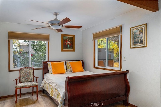 bedroom featuring beamed ceiling, ceiling fan, and wood-type flooring