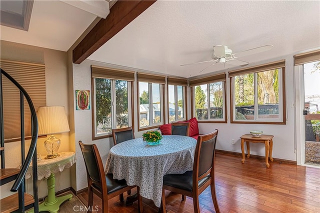 sunroom / solarium featuring beamed ceiling and ceiling fan