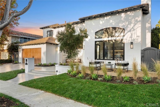 view of front of property featuring a lawn and a garage