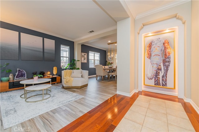 living room featuring a chandelier, light hardwood / wood-style floors, and ornamental molding