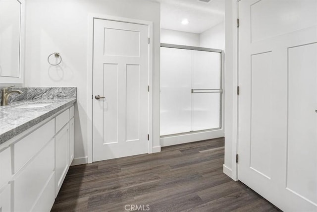 bathroom featuring vanity, wood-type flooring, and a shower with shower door